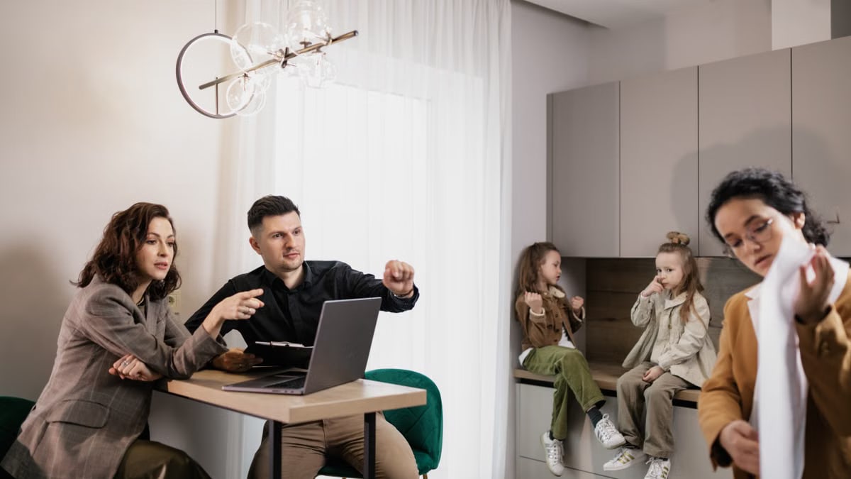 Family discussing real estate purchase inside home with agent and children present.